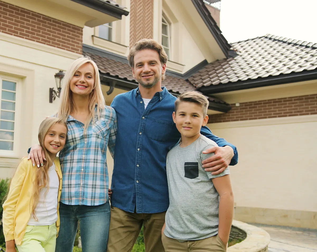 Happy Family Standing Outside Garage Door