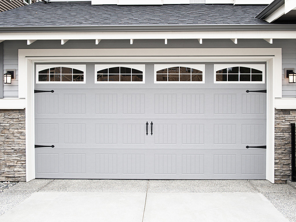 Modern Gray Garage Door With Decorative Windows and Stone Detailing