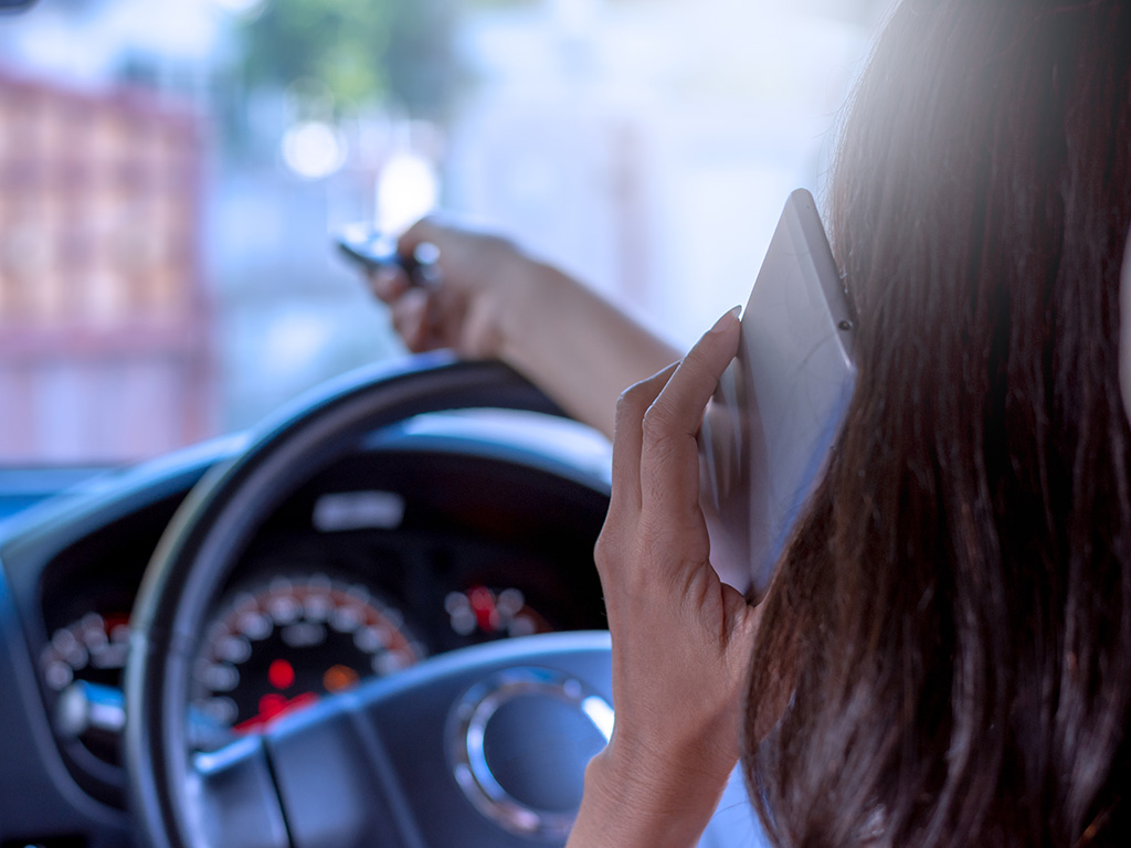 Person in Car Using Phone and Remote for Garage Door Opener